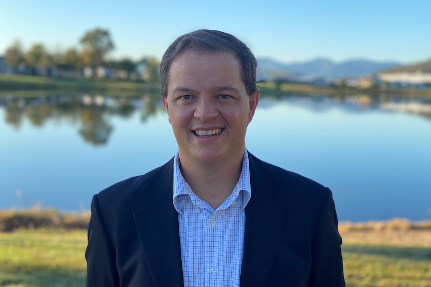 Dr Michael Clements with a blurred background of a lake and mountains