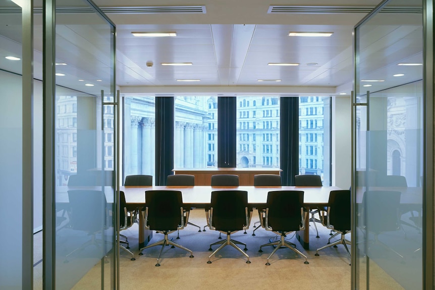 An empty boardroom with chairs around a table