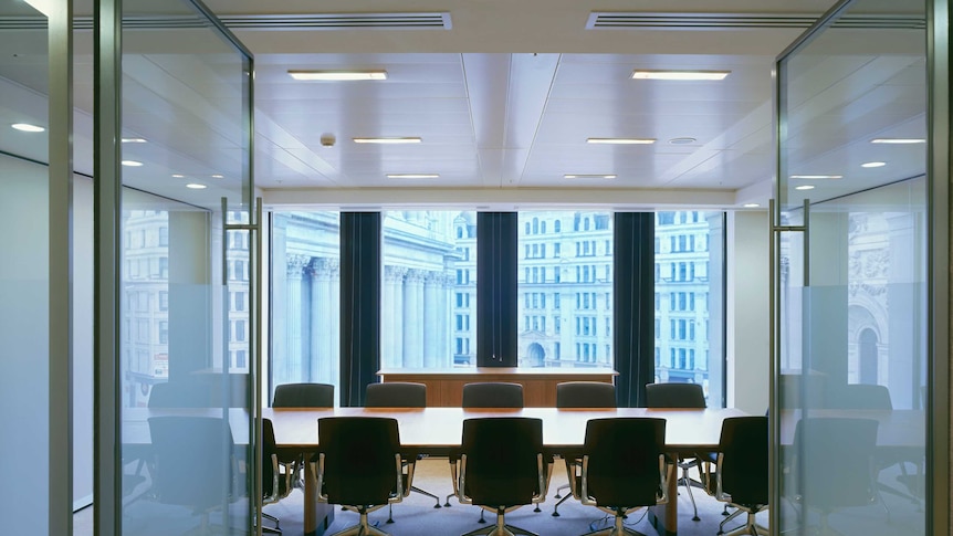 An empty boardroom with chairs around a table