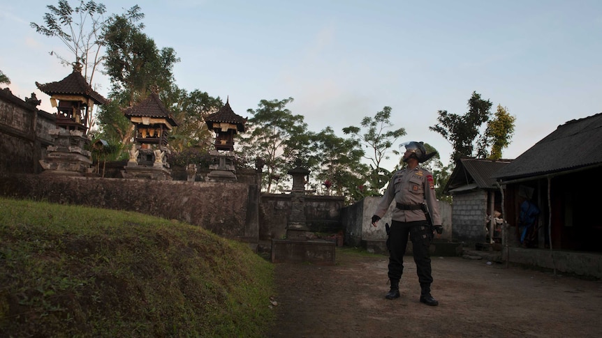 An officer checks a village to ensure all residents have evacuated amid increased seismic activity on the volcano