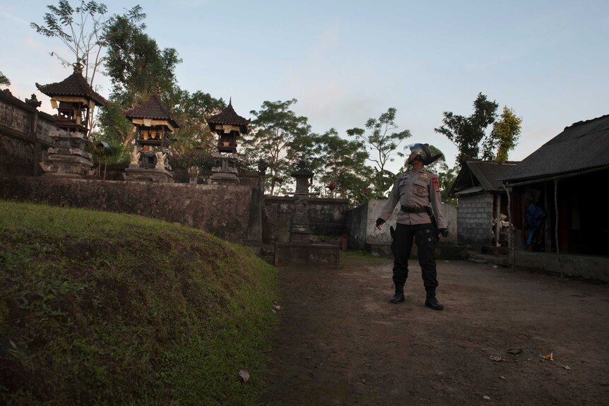 An officer checks a village to ensure all residents have evacuated amid increased seismic activity on the volcano