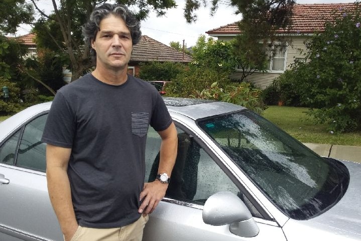 Driver Lyle Bedford stands next to his car