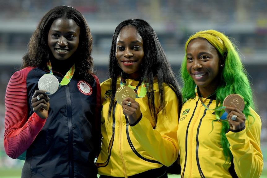 Tori Bowie (left) poses with silver medal alongside Elaine Thompson (centre) and Shelly-Ann Fraser-Pryce.