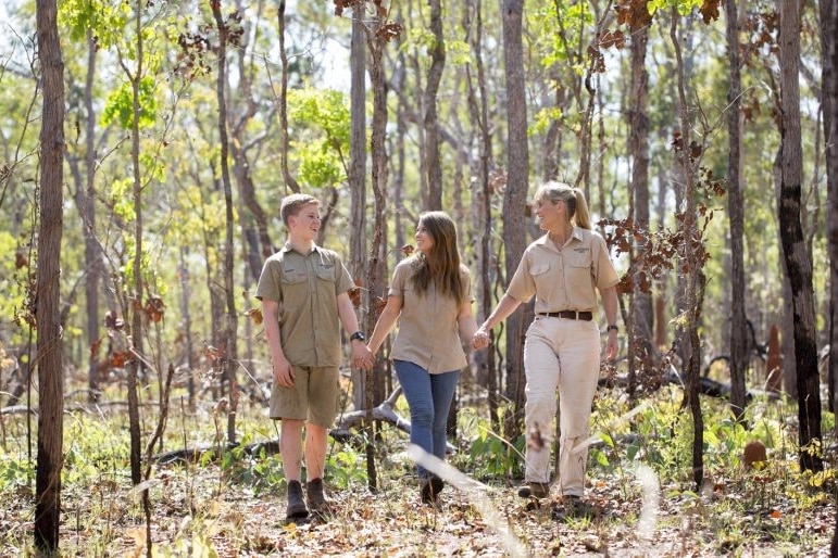 a family walks through bushland