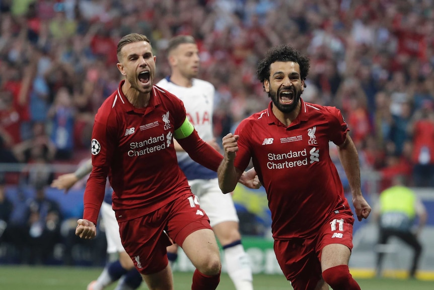 Liverpool's Mohamed Salah, right, celebrates after scoring his side's opening goal