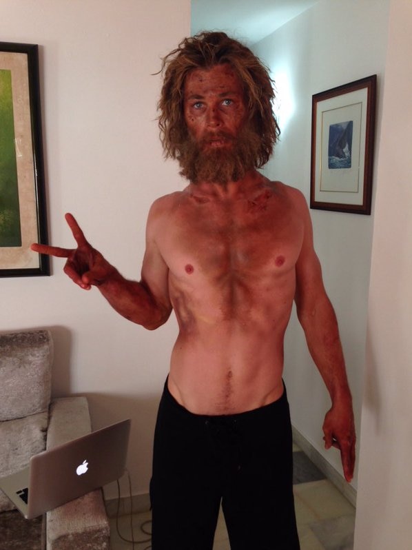 Australian actor Chris Hemsworth with shaggy hair, a beard and sunburn makeup.