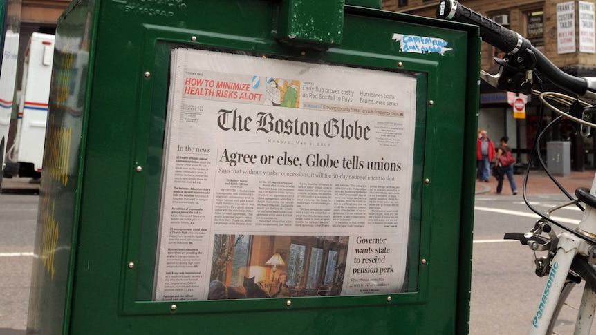 A Boston Globe newspaper sits inside a vendor box 2009