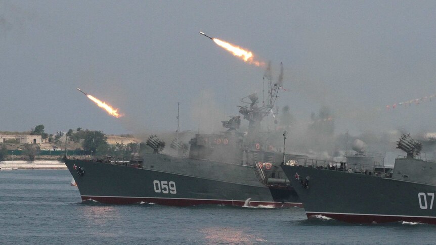 Russian warships fire during a naval parade rehearsal in the Crimean port of Sevastopol, July 25, 2014.