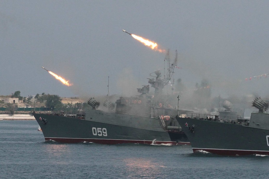 Russian warships fire during a naval parade rehearsal in the Crimean port of Sevastopol, July 25, 2014.