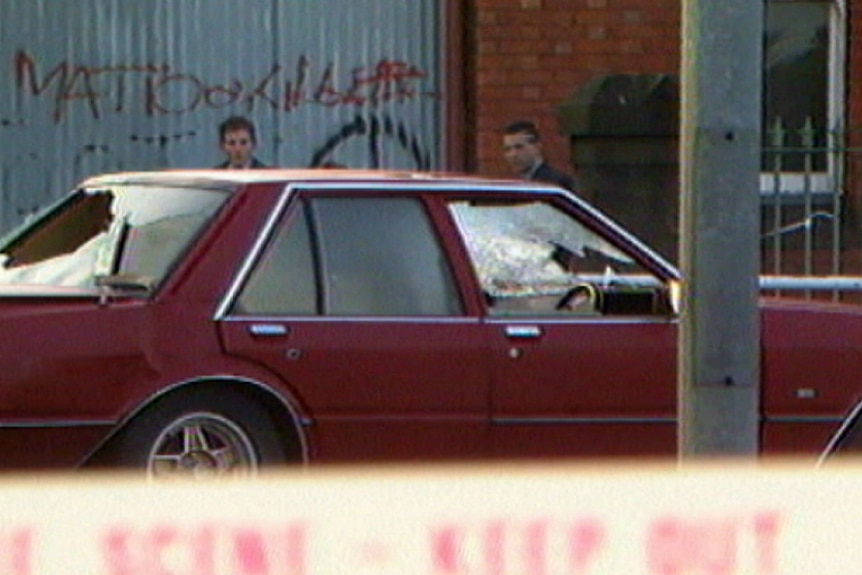 A car with smashed windows from bullet holes.