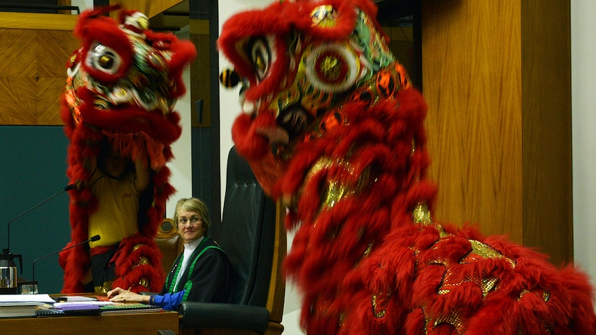 NT Parliamentary Speaker Kezia Purick sits at her chair while ceremonial Chinese lions perform.