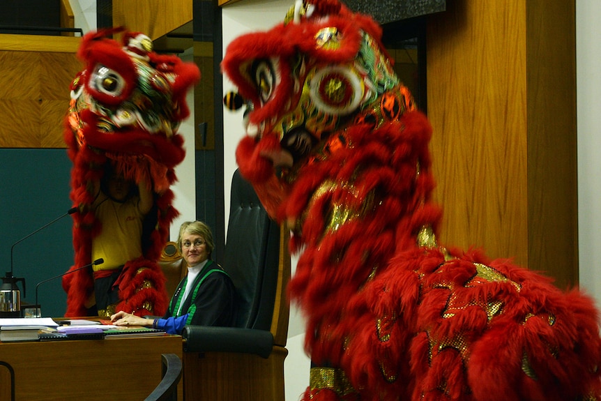 NT Parliamentary Speaker Kezia Purick sits at her chair while ceremonial Chinese lions perform.