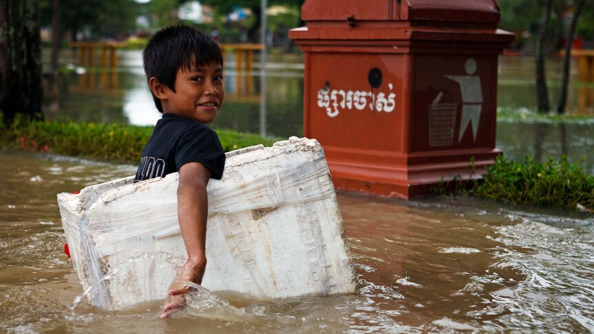 A boy paddles through floodwaters in a box in Siem Reap in late September, 2011.