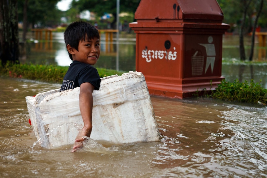 A boy paddles through floodwaters in a box in Siem Reap in late September, 2011.