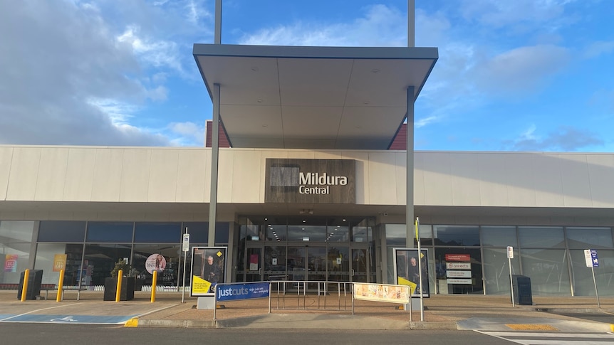 A partly cloudy sky above a large sign saying "Mildura Central" over a glassed entryway.