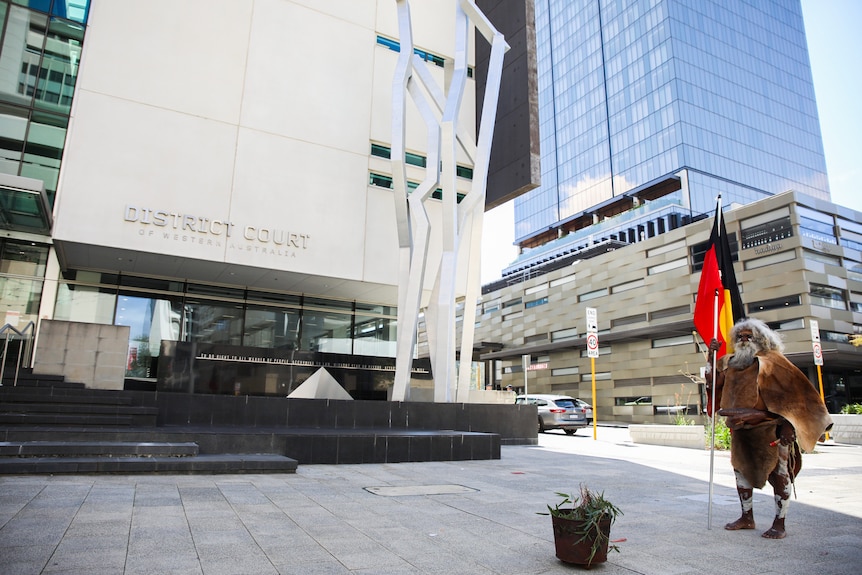 An Aboriginal man stands outside the Perth District Court.