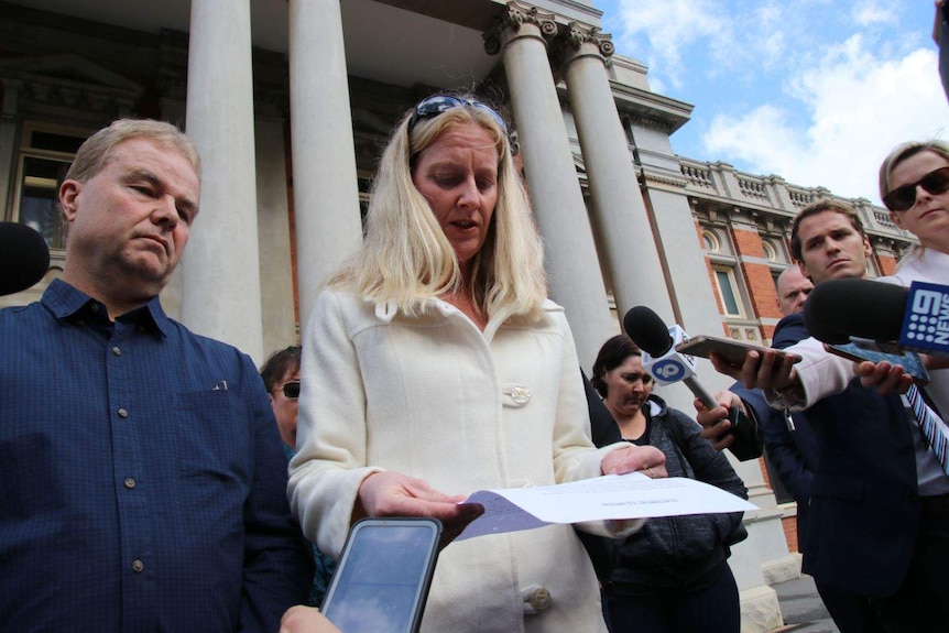 Taryn Tottman, sister of murdered woman Mara Harvey, is surroundewd by reporters as she reads from a written statement.