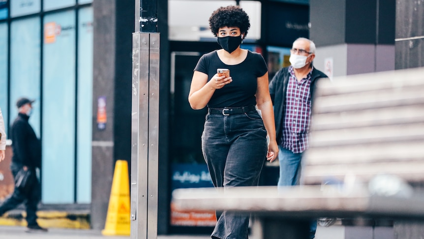 a young woman using her phone while walking