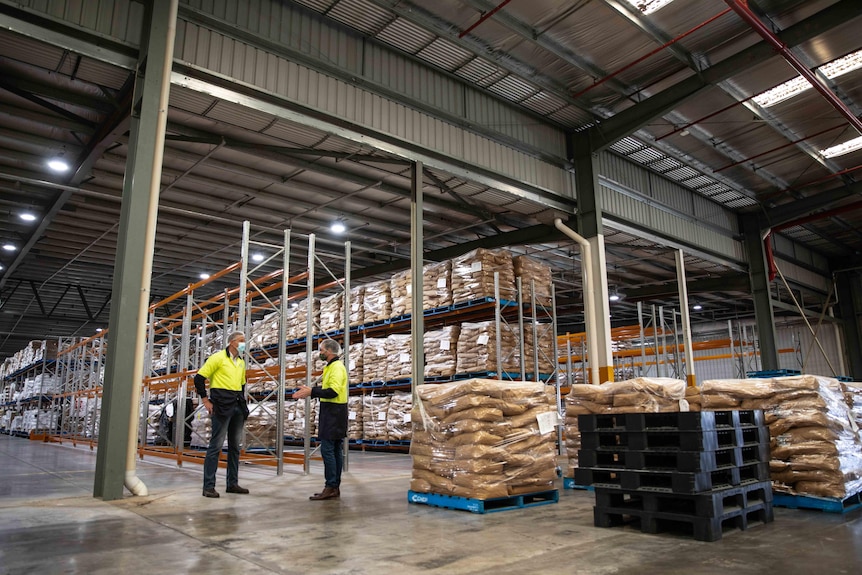 A large warehouse filled with brown paper sacks of soy powder.