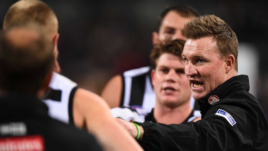 Collingwood coach Nathan Buckley (R) addresses the team at three-quarter-time against Fremantle.