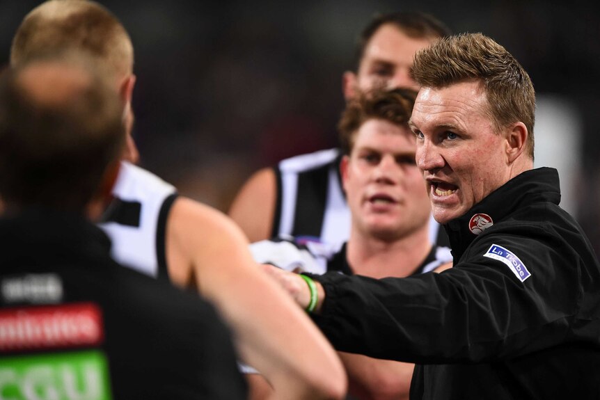 Coach Nathan Buckley addresses Collingwood players at three-quarter time against Fremantle