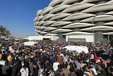 Two ambulances try to get through thousands of soccer fans outside the Basra International Stadium.