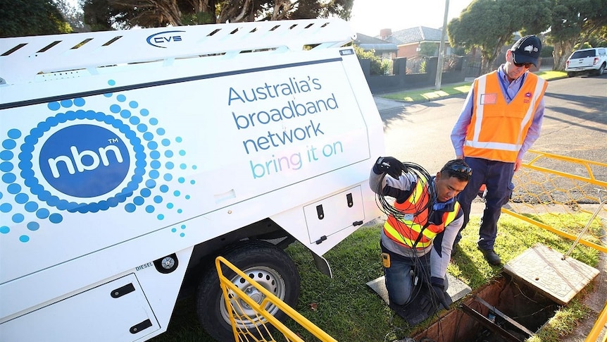 Workers installing NBN fibre to the node next to NBN truck