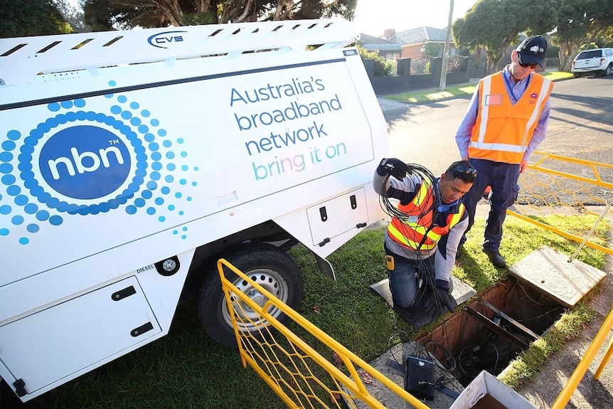 Workers installing NBN fibre to the node next to NBN truck