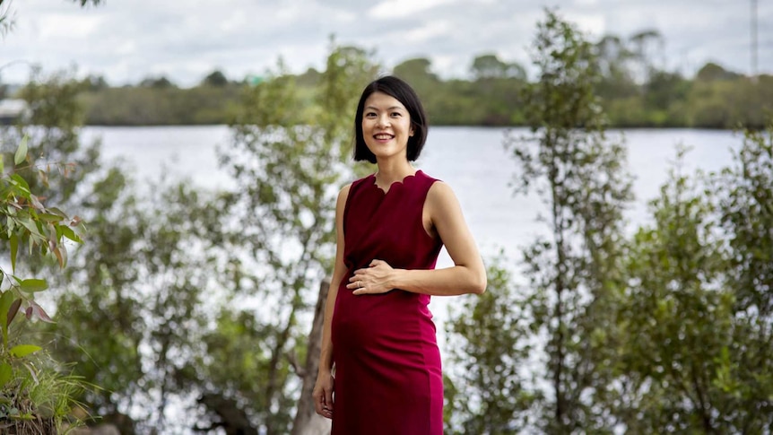 Tammy Law standing in nature holding her pregnancy bump for a story about being pregnant during the coronavirus pandemic.