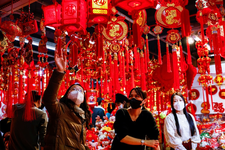 Un client se uită la decorațiunile de Anul Nou Lunar din piață.
