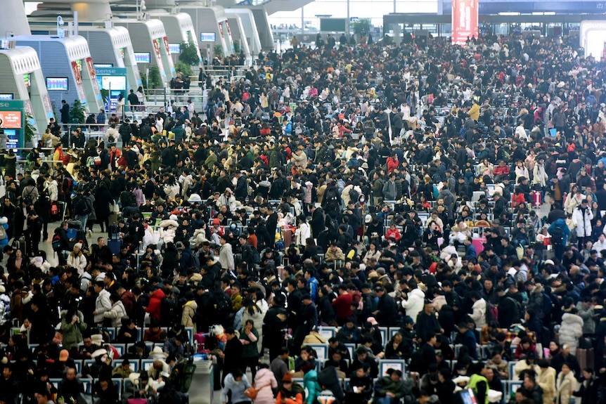A huge throng of passengers wait for their trains at the Hangzhou East Railway Station.