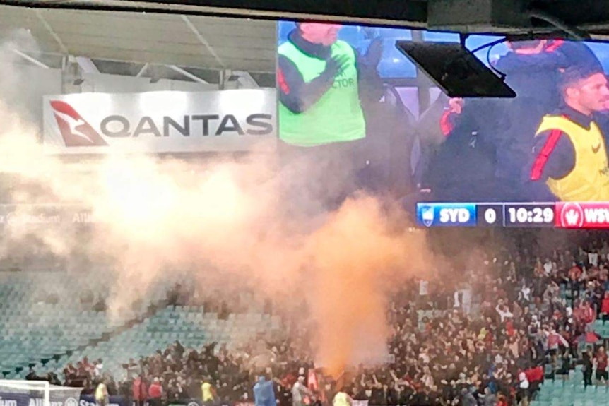 Long shot of flares in the crowd at the stadium.