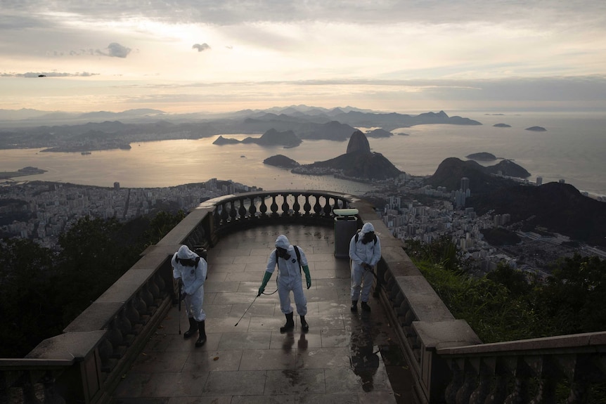 Soldiers disinfect the closed Christ the Redeemer site as islands and coast line can be seen in the background.