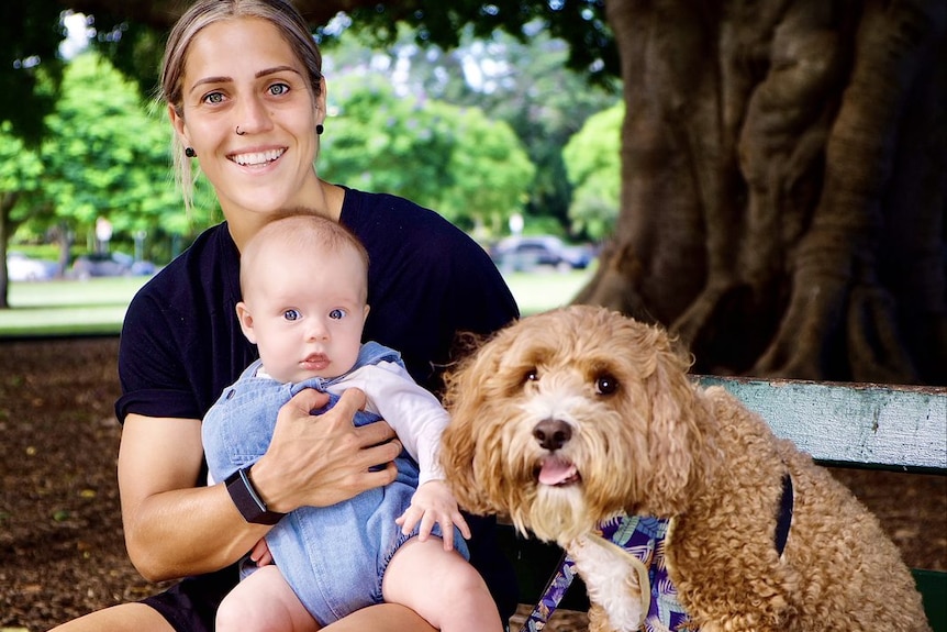 Katrina Gorry and her baby Harper and dog Rio in a Brisbane park.