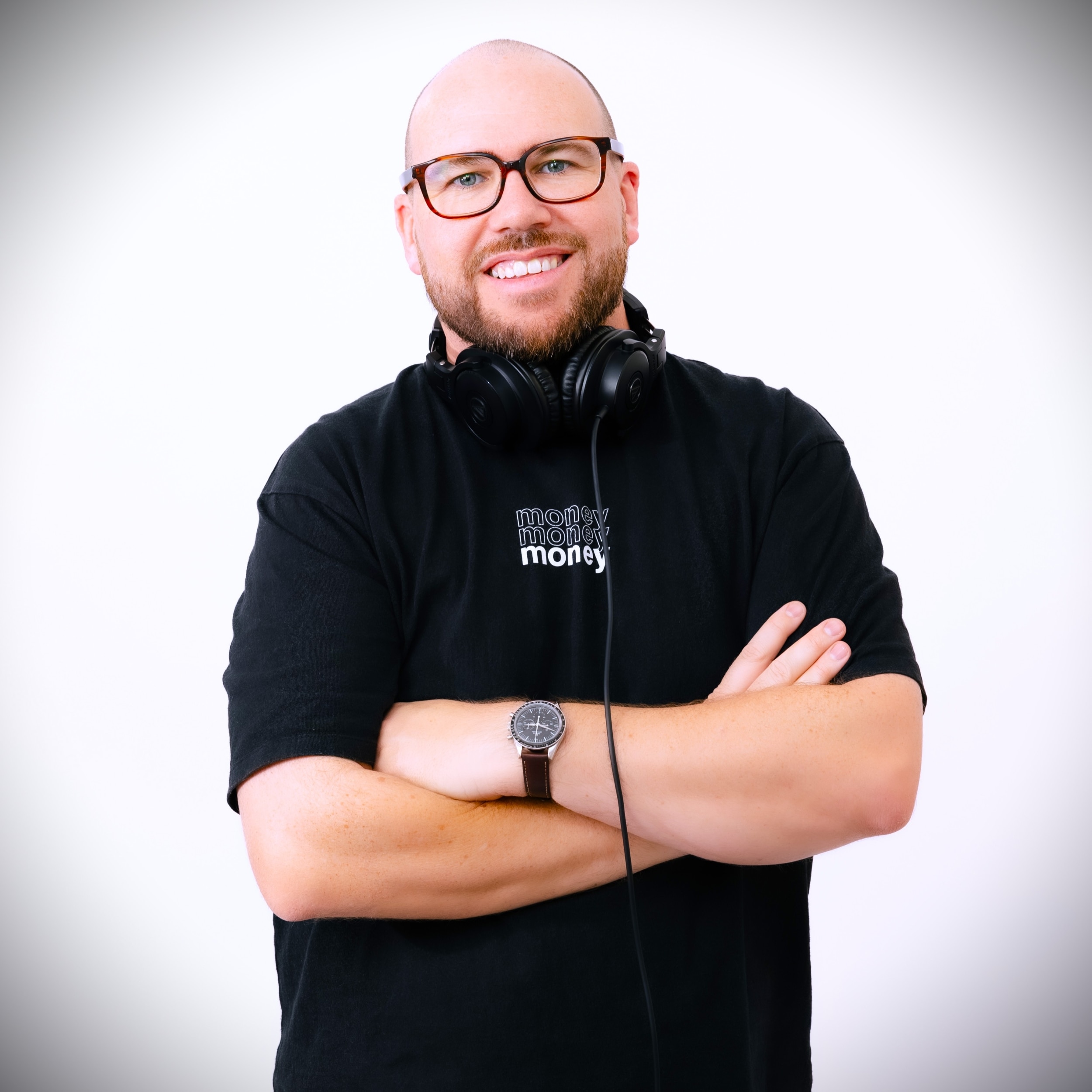 A smiling young man with headphones around his neck faces the camera.