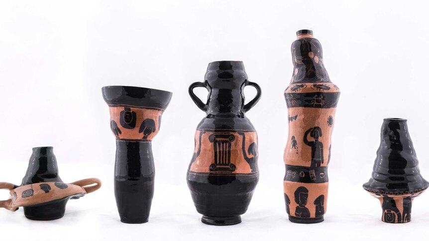 A set of five black and rose gold pots with hieroglyphics inspired drawings