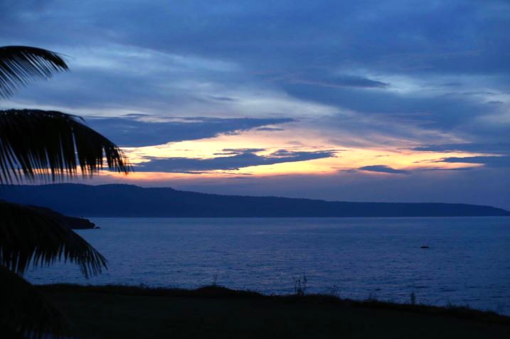 A wide shot of a sunset on Christmas Island under blue sky and clouds.