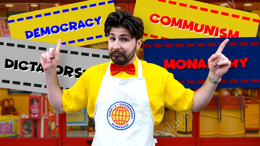 Joe wearing a 'Build-A-Government' apron points at signs showing different governments like Monarchy and Democracy.