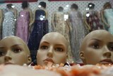 The heads of mannequins (foreground) are seen at a at a women's clothing store