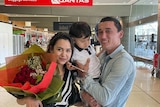 Sadam Abudusalamu poses for a photo with his wife and child after their arrival in Australia