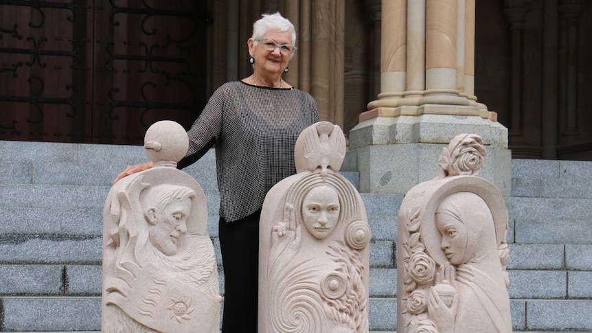 Brisbane artist Rhyl Hinwood standing with her creations