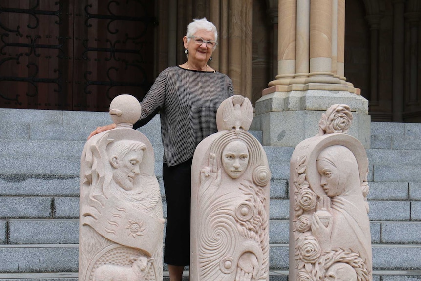 Brisbane artist Rhyl Hinwood standing with her creations