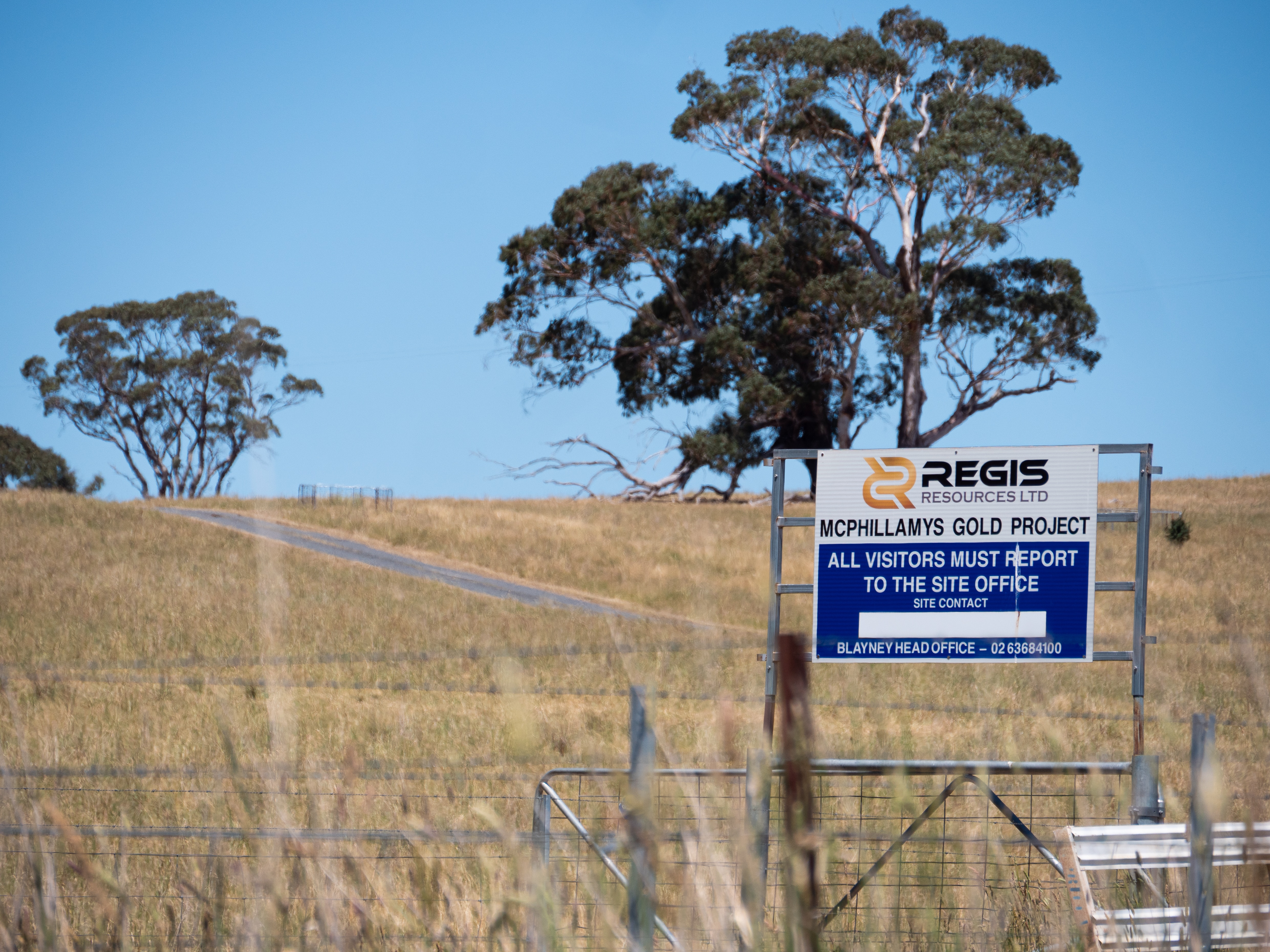 Tierras de cultivo con potreros, carteles y vallas.