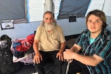 Queensland man Michael Reid and son sit in their tent