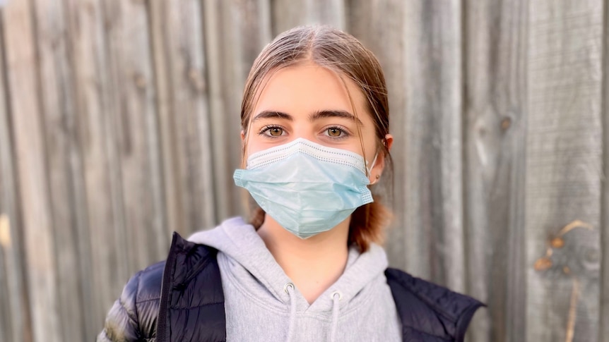 Isla Ayoub, a 12-year-old girl wearing a face mask and a puffer jacket.
