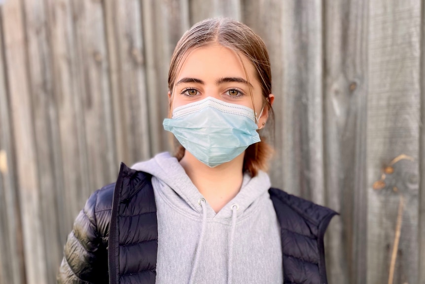 Isla Ayoub, a 12-year-old girl wearing a face mask and a puffer jacket.