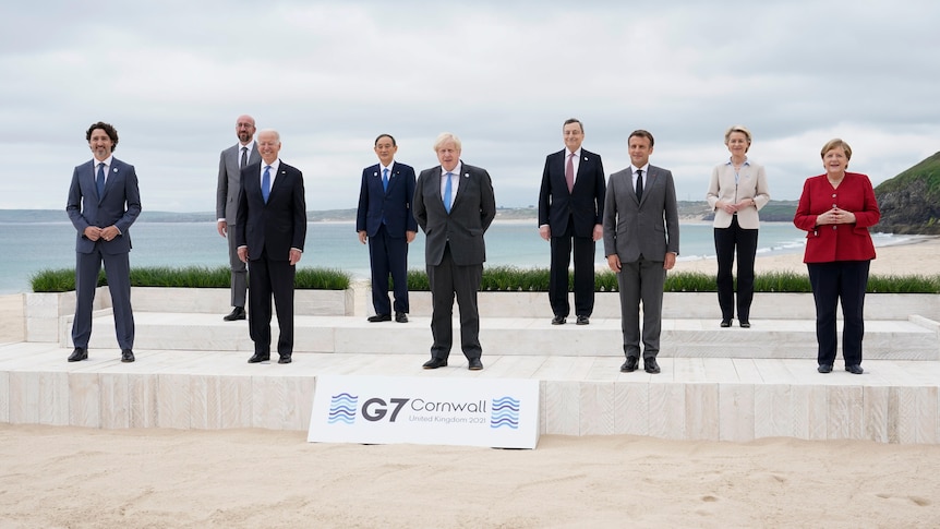 Leaders of the G7 pose for a group photo on overlooking the beach at Carbis Bay