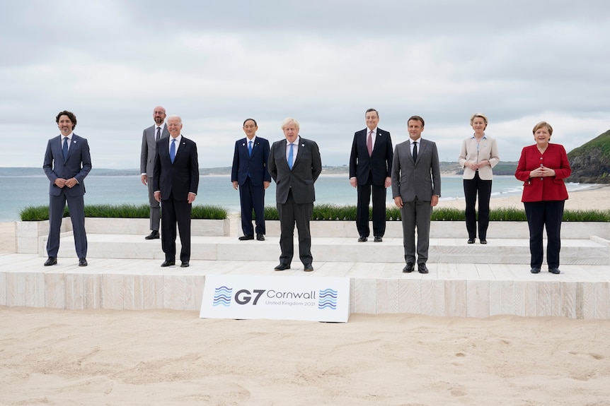 Leaders of the G7 pose for a group photo overlooking the beach at Carbis Bay