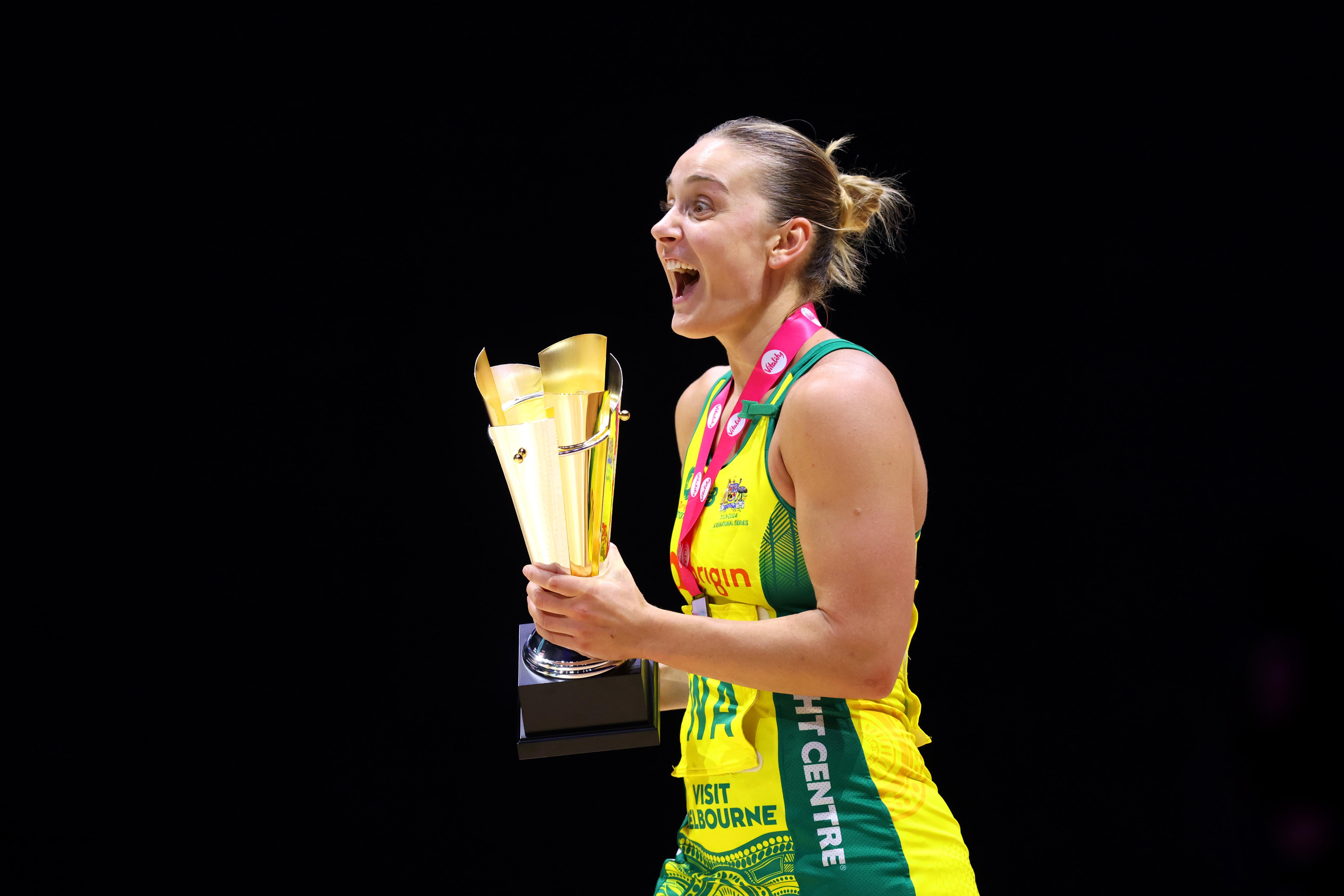 A woman celebrates winning a netball match