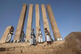 soldiers pose on the steps of the Awwam Temple in Yemen